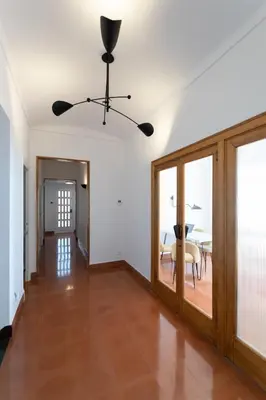 a living room with a ceiling fan and a table at Villa Can Bagués in Mataró