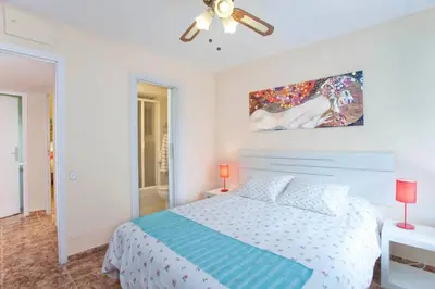 a bedroom with a bed and a painting on the wall at Apartment Llavaneres I in Sant Andreu de Llavaneres