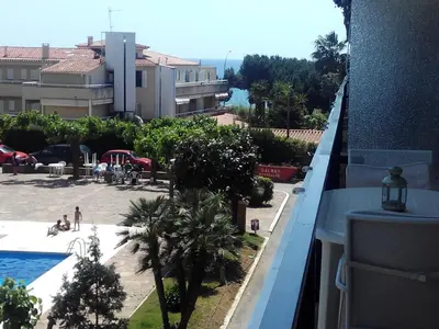 a large blue swimming pool in front of a building at Apartment Llavaneres I in Sant Andreu de Llavaneres