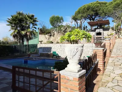 a vase sitting on a brick wall next to a pool at Habitaciones en Villa Coliving Casa Rural in San Fausto de Campcentellas