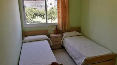 two beds in a small room with a window at Casa Ana -Cubelles in Cubelles
