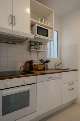 a kitchen with white cabinets and a microwave at Nice Apartment in Barcelona
