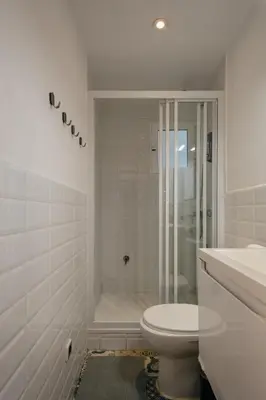 a white bathroom with a toilet and a shower at Nice Apartment in Barcelona