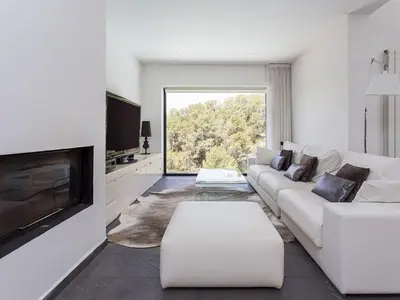 a white living room with a white couch and a tv at Architect modern design villa in Sitges Hills in Olivella