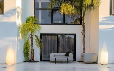 a living room with two chairs and palm trees at Architect modern design villa in Sitges Hills in Olivella