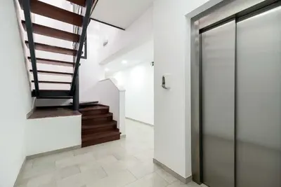 a hallway with a glass door and stairs at Castell Beach Aparthotel in Castelldefels