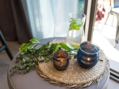 a table with three candles and a vase on it at Sitges Spaces Seaside Beach Flat- 4 Bedroom, 2 Bathroom, Terrace, Near Beach in Sitges