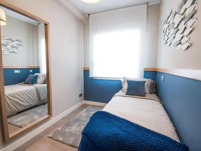 a bedroom with a mirror next to a bed at Sitges Spaces Seaside Beach Flat- 4 Bedroom, 2 Bathroom, Terrace, Near Beach in Sitges