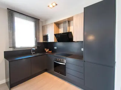 a kitchen with black cabinets and a microwave and a window at Sitges Spaces Seaside Beach Flat- 4 Bedroom, 2 Bathroom, Terrace, Near Beach in Sitges