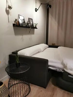 a bedroom with a black bed and a table at Apartaments Agulles de Montserrat in Monistrol