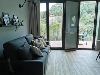 a living room with a couch and a sliding glass door at Apartaments Agulles de Montserrat in Monistrol