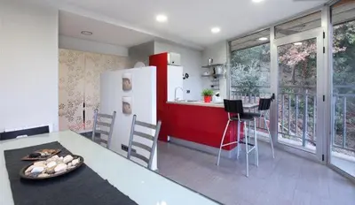 a kitchen with a refrigerator and a table with chairs at Les Suites in Santa María de Palautordera