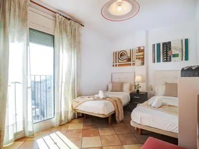 a bedroom with two beds and a large window at Linda Vista Oasis Penthouse by Hello Homes Sitges in Sitges