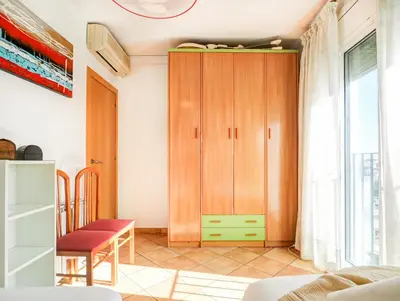 a living room with a wooden cabinet and a window at Linda Vista Oasis Penthouse by Hello Homes Sitges in Sitges