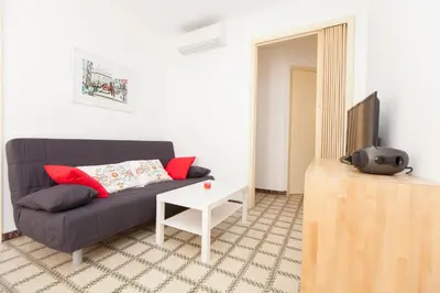 two beds in a white room with red and orange at Stay Barcelona Plaza España Fira in Barcelona