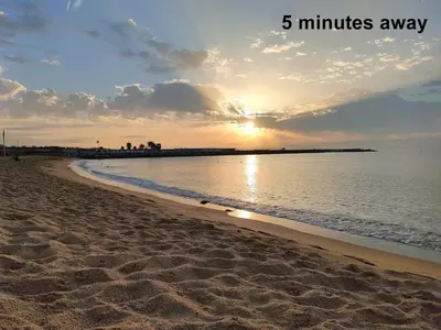 a beach with the sun setting over the water at Hotel BESTPRICE Diagonal in Barcelona
