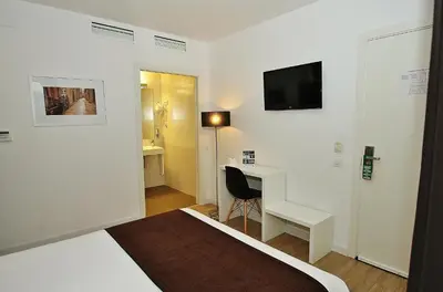 a white room with a desk and a television on the wall at Hotel BESTPRICE Diagonal in Barcelona