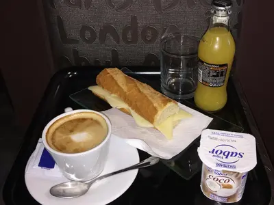 a tray with a sandwich and a cup of coffee and a drink at Hotel BESTPRICE Diagonal in Barcelona
