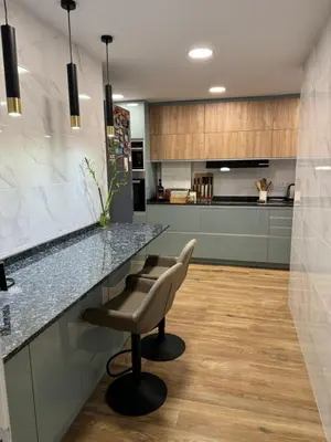 a kitchen with a counter and a bar with a chair at Habitación Amaya 2 in Las Corts