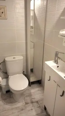 a white bathroom with a toilet and a sink at Beachfront Apartment with Sea Views & Private Parking in San Pol de Mar
