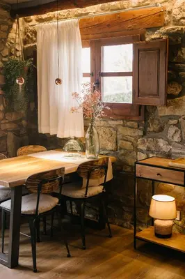 a wooden table with chairs and a vase of flowers at La Caseta del Munt in Castelltersol