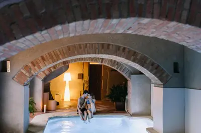two people jumping into a swimming pool in a building at La Caseta del Munt in Castelltersol