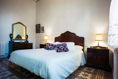a bedroom with a bed with two dressers and a mirror at Cal Peó B&B Cardedeu in Cardedeu