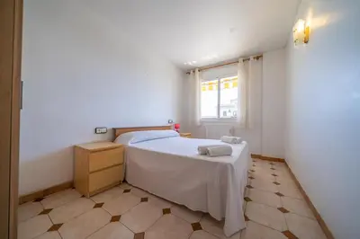 a small bedroom with a bed and a window at HomeHolidaysRentals Destan - Costa Barcelona in Pineda de Mar