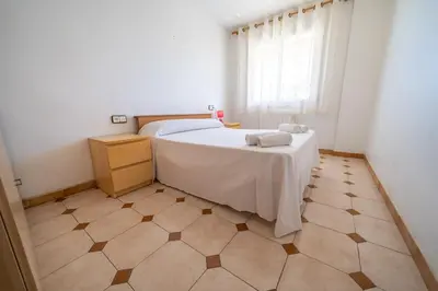 a bedroom with a bed and a tiled floor at HomeHolidaysRentals Destan - Costa Barcelona in Pineda de Mar