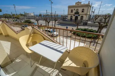 a balcony with two chairs and a building with a street at HomeHolidaysRentals Destan - Costa Barcelona in Pineda de Mar