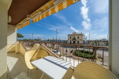 a balcony with a table and chairs and a view of the harbor at HomeHolidaysRentals Destan - Costa Barcelona in Pineda de Mar