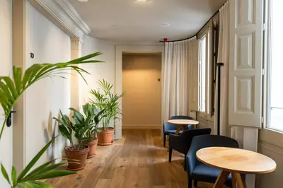 a room with two tables and chairs and plants at Colectia Stays Pau Claris in Barcelona