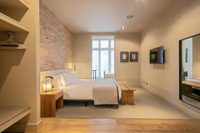 a bedroom with a bed and a brick wall at Colectia Stays Pau Claris in Barcelona