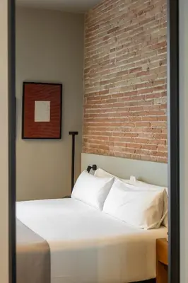 a bed in a room with a brick wall at Colectia Stays Pau Claris in Barcelona