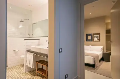 a bathroom with a sink and a bed in a room at Colectia Stays Pau Claris in Barcelona