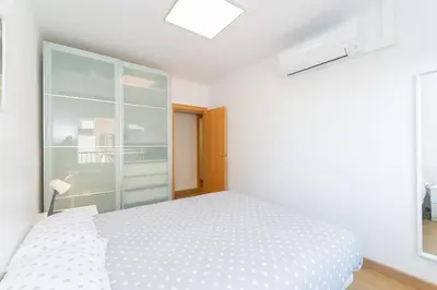 a white bedroom with a bed and a window at Cadillac Check-in flexible-Bien comunicado-cerca Barcelona in Cornellà de Llobregat