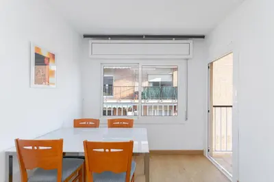 a dining room with a white table and chairs at Cadillac Check-in flexible-Bien comunicado-cerca Barcelona in Cornellà de Llobregat