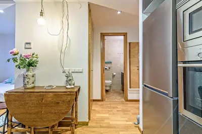 a kitchen and a dining room with a table and a refrigerator at Tata's House, junto playa y Barcelona Centro in Masnou