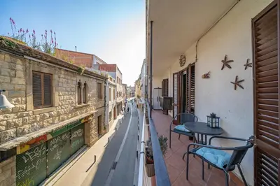 a balcony with tables and chairs on a street at HomeHolidaysRentals Plume - Costa Barcelona in Pineda de Mar