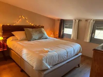 a bedroom with a large bed with white sheets at PassiveRooms in Vilanova i la Geltrú