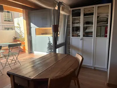 a dining room with a wooden table and chairs at PassiveRooms in Vilanova i la Geltrú