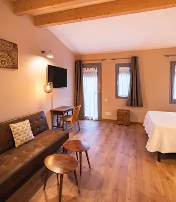 a living room with a couch and a bed and a table at PassiveRooms in Vilanova i la Geltrú