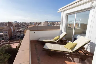 a balcony with two chairs and a view of a city at Gaudi penthouse with terrace views in Barcelona