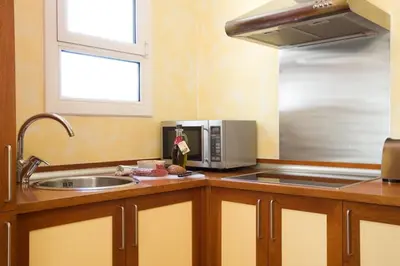 a kitchen with a sink and a microwave at Gaudi penthouse with terrace views in Barcelona