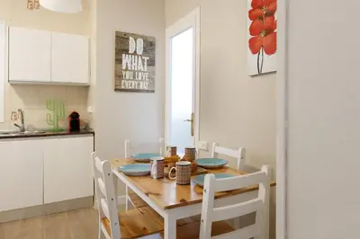 a kitchen with a wooden table and white chairs at Mercat Sant Antoni 4 in Barcelona