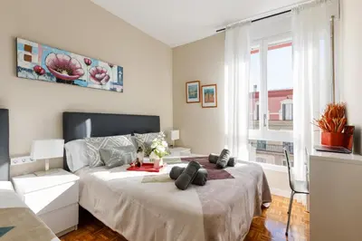 a bedroom with two beds and a large window at Mercat Sant Antoni 4 in Barcelona