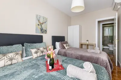 a bedroom with two beds and a table with flowers at Mercat Sant Antoni 4 in Barcelona