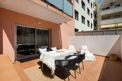 a patio with a table and chairs on a balcony at Aparthotel Centric in Castelldefels