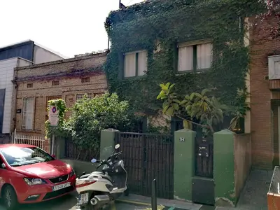a red scooter parked in front of a building at Estudio Finestrelles Barcelona in Esplugues de Llobregat