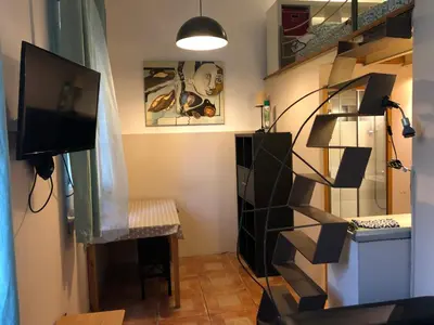 a living room with a staircase and a television at Estudio Finestrelles Barcelona in Esplugues de Llobregat